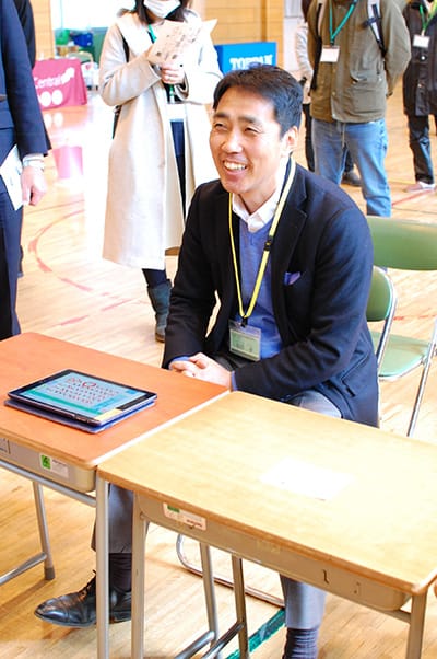 「マイクロビット宝探し」で“お宝証明書”の引き換え会場(体育館)で児童を待つ松田孝校長